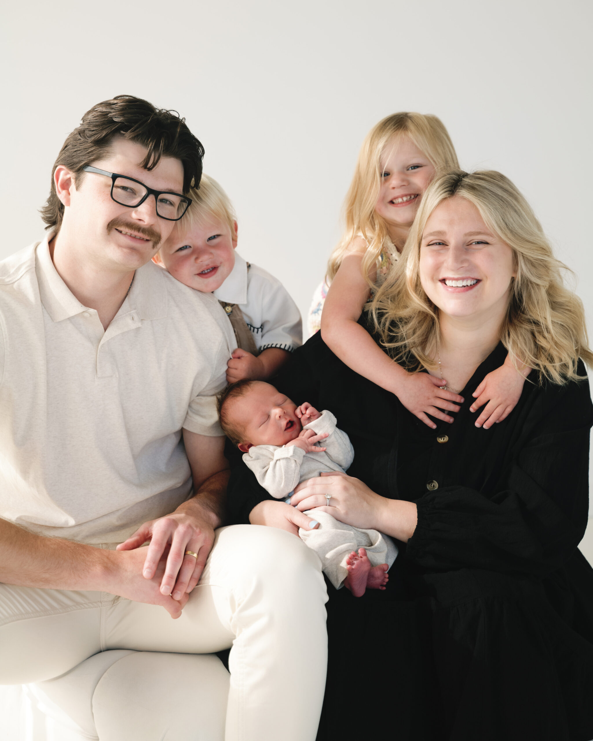 Family wearing neutral outfits during relaxed photo session in downtown Fargo